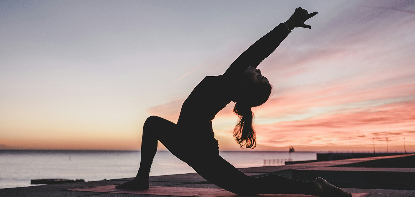 A person doing yoga at sunset